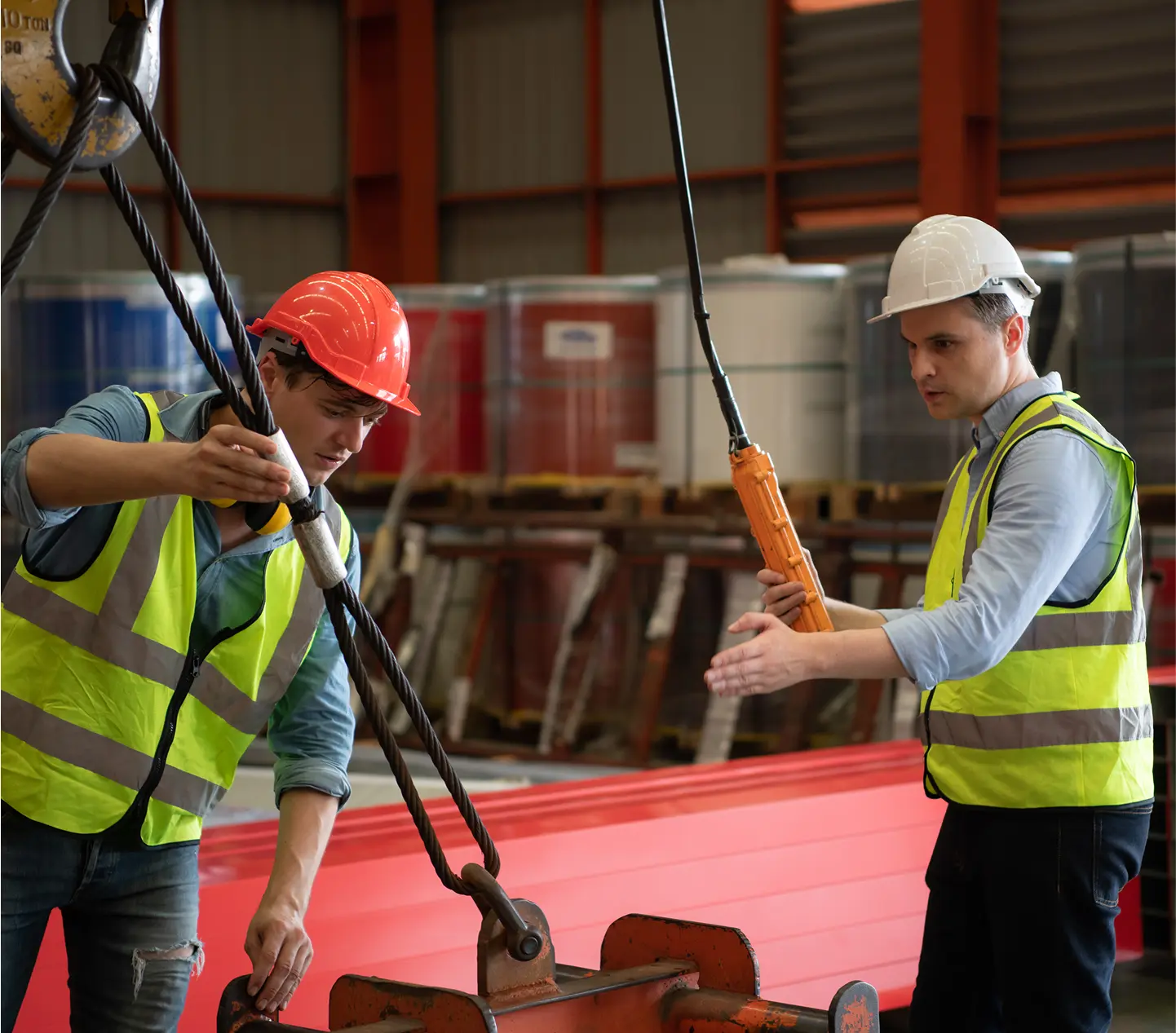 Workers operating machinery in a warehouse.