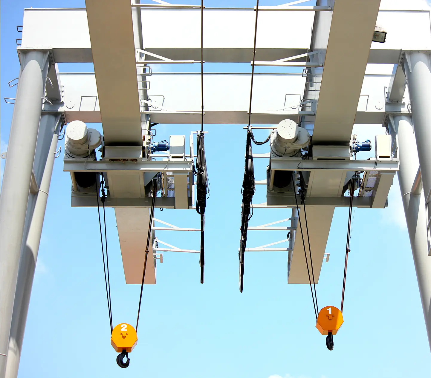 Overhead crane system with hooks and cables.
