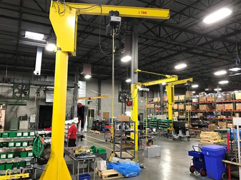 Warehouse with yellow industrial cranes and shelves.