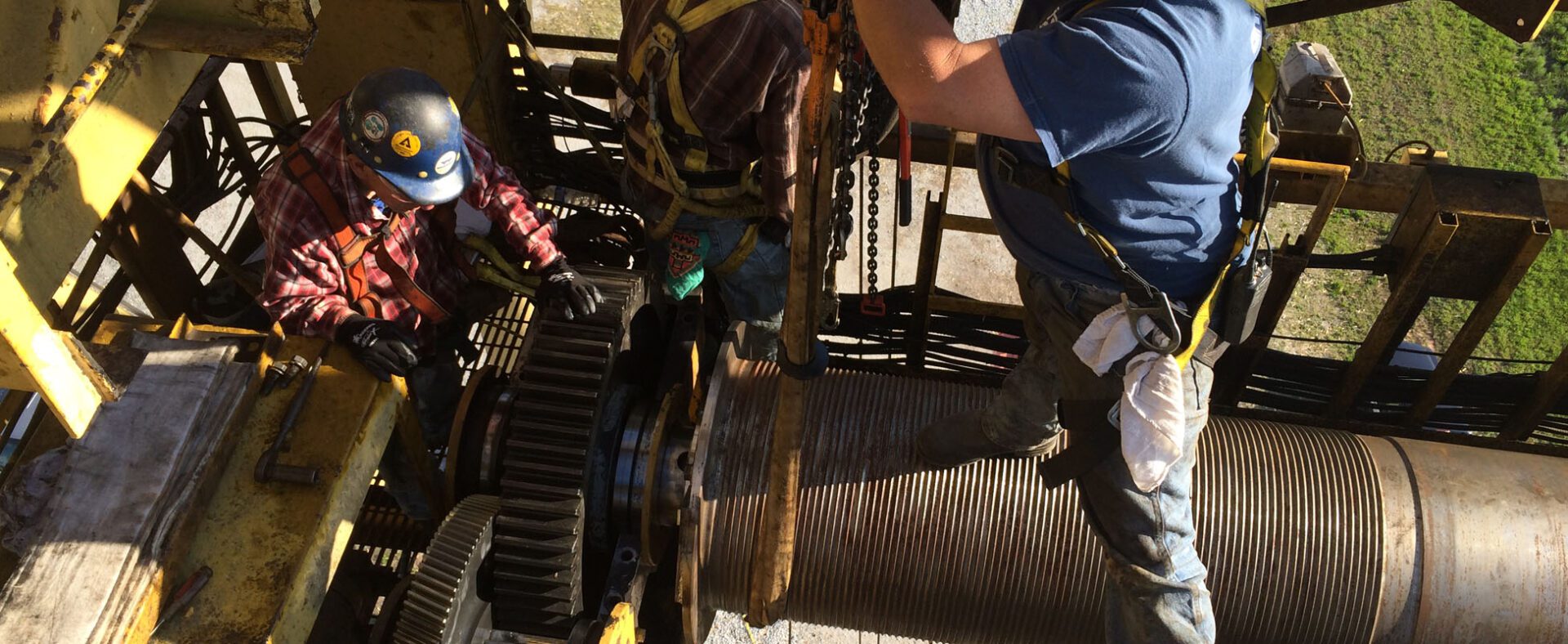 Workers repairing industrial machinery on site.